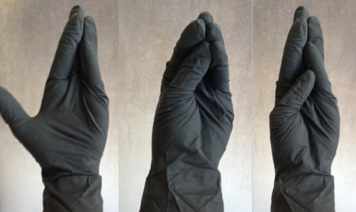 Three shots of the same hand wearing a black latex glove, showing different hand positions that can help with fisting. This first one has all fingers but the thumb meeting at the tip; the thumb stands well apart. The second and third one have a different thumb placement. The thumb rests right under where the other fingers meet in the second one. It rests closer to the base of the fingers in the third one.